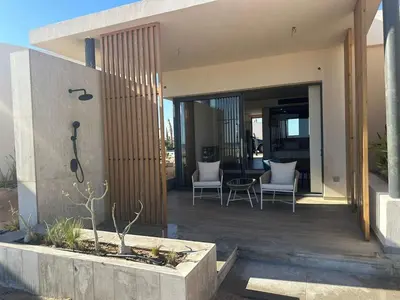 a house with a patio with chairs and a table at Barefoot Beachfront Cabana with Open SeaView,Mesca in Hurghada