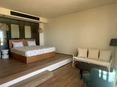 a bedroom with a bed and a couch and a chair at Barefoot Beachfront Cabana with Open SeaView,Mesca in Hurghada