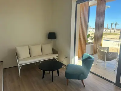 a living room with a couch and a chair and a table at Barefoot Beachfront Cabana with Open SeaView,Mesca in Hurghada