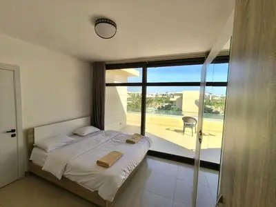 a bedroom with a bed with a view of a balcony at Gcrips in El Gouna