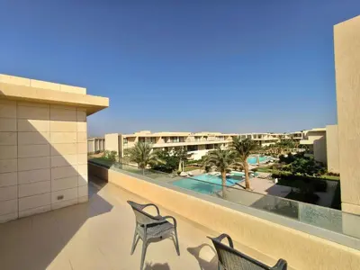 a balcony with two chairs and a view of a pool at Gcrips in El Gouna