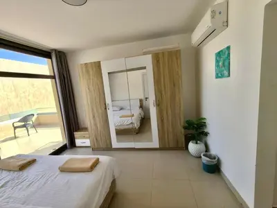 a bedroom with a bed and a large mirror at Gcrips in El Gouna