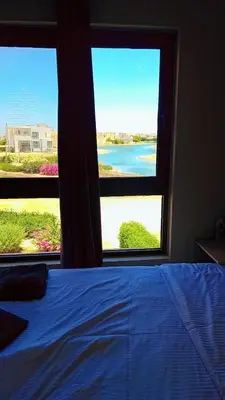 a bedroom with a bed and two windows with a view at Hayloft 1 bedroom tawila, Plaza ElGouna in Hurghada