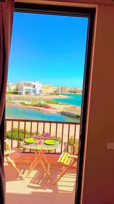 a balcony with a table and a view of the ocean at Hayloft 1 bedroom tawila, Plaza ElGouna in Hurghada