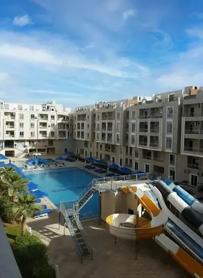 a large apartment complex with a pool and a slide at HUB resort Luxury apartment on the pool in Hurghada
