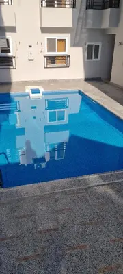 a swimming pool with blue water in front of a building at La Bellal Star Hurghada A103 in Hurghada