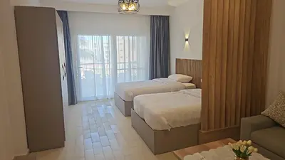 a hotel room with two beds and a couch at Paradise Studio with pool in Hurghada