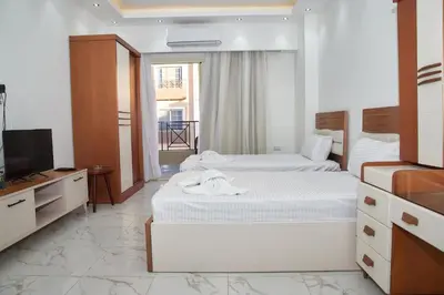 a bedroom with two beds and a flat screen tv at Juliana beach luxury family suites in Hurghada