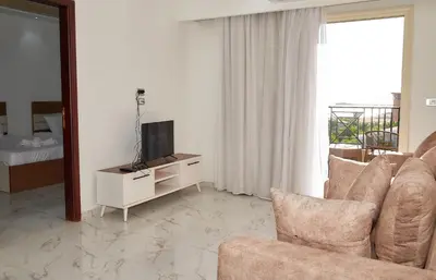a living room with a couch and a television at Juliana beach luxury family suites in Hurghada