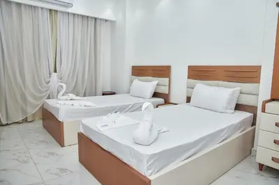 a bedroom with two beds with white sheets and towels at Juliana beach luxury family suites in Hurghada