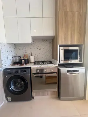 a kitchen with a washing machine and a microwave at Boho El Gouna Shedwan 2BD Beach & Pool Access in Hurghada