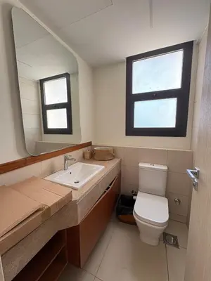 a bathroom with a sink and a toilet and a mirror at Boho El Gouna Shedwan 2BD Beach & Pool Access in Hurghada