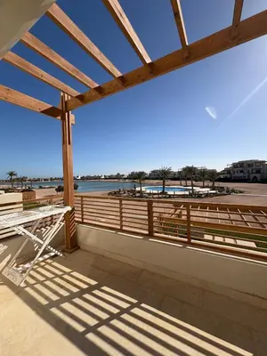 a deck with a table and a view of the beach at Boho El Gouna Shedwan 2BD Beach & Pool Access in Hurghada