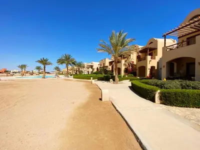 a street in a resort with palm trees and houses at El Gouna - Sabina - Lagoon Chalet - 2 bedrooms - Ground Floor in El Gouna
