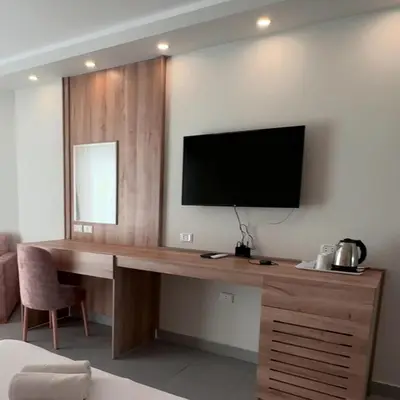 a room with a desk with a television on a wall at Scandic resort near diving center Colona Divers Hotel Room in Hurghada