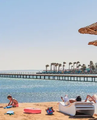a group of people laying on the beach near the water at Scandic resort near diving center Colona Divers Hotel Room in Hurghada