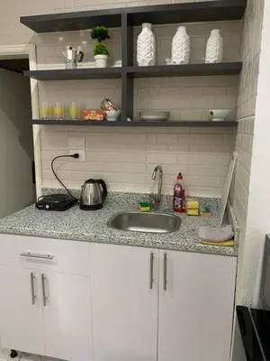 a kitchen counter with a sink and white cabinets at Sea Light Arabia in Hurghada