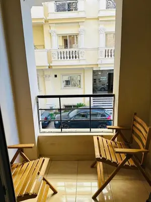 a balcony with two chairs and a view of a building at apartment 20 in Hurghada