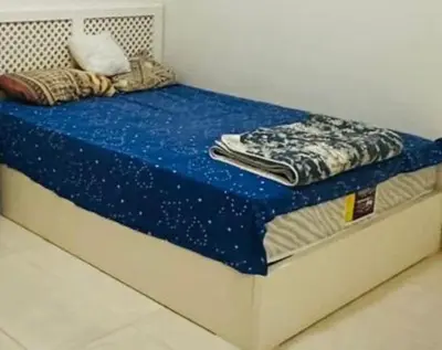 a bed with a blue comforter on top of it at apartment 20 in Hurghada