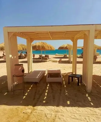 a pavilion on the beach with chairs and umbrellas at Princess Resort Hurghada in Hurghada