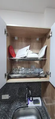 a kitchen counter with a sink and a shelf with utensils at Tiba Golden Resort in Hurghada