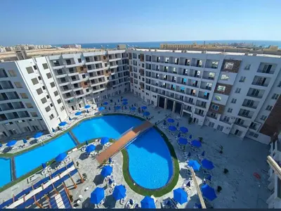 an aerial view of a hotel with a pool and chairs at Tiba Golden Resort in Hurghada