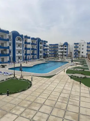 a large swimming pool in front of some apartment buildings at Apartment for Rent Hurghada, Oasis Marina Resort in Hurghada