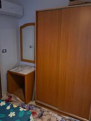 a bedroom with a wooden cabinet and a mirror at Apartment for Rent Hurghada, Oasis Marina Resort in Hurghada