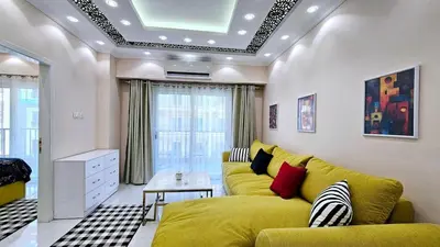 a living room with a yellow couch and a table at Apartment 95sqm with sea view in Hurghada