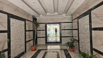 a room with potted plants and a person standing outside a window at Apartment 95sqm with sea view in Hurghada