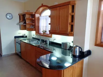 a kitchen with wooden cabinets and a black counter top at One bedroom apartment with stunning sea view in Hurghada