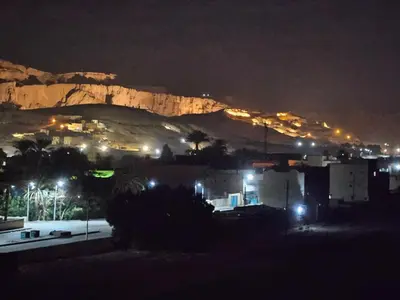 a city at night with a mountain in the background at Hepton hotel