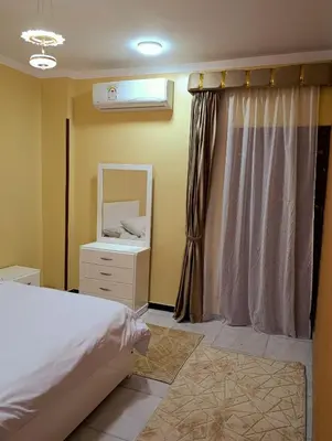 a bedroom with a bed and a dresser and a mirror at Lutos flower apartment 2 in Al Karnak
