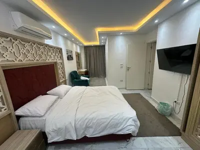 a bedroom with a large bed and a flat screen tv at Elegant 3BR Luxury Suite - Fanadir Bay in Hurghada