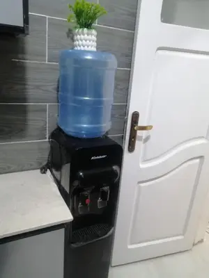 a blue water cooler in a kitchen next to a door at بيت الاستجمام in Idfū
