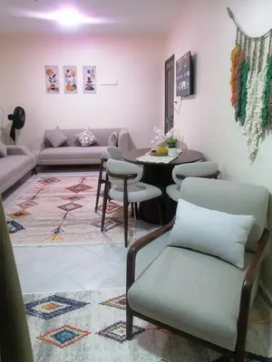 a living room with a couch and a table and chairs at بيت الاستجمام in Idfū
