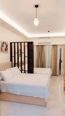 a large bedroom with two beds and a table at Juliana beach resort in El Gouna