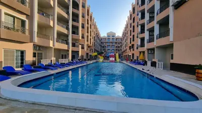 a swimming pool in the middle of some apartment buildings at Juliana beach resort in El Gouna