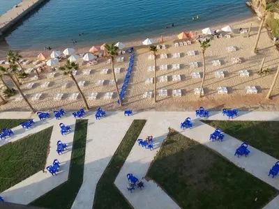 an overhead view of a beach with blue chairs and the ocean at Juliana beach resort in El Gouna