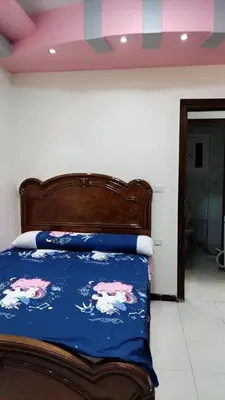 a bedroom with a bed with a blue comforter at Apartment in sherry street near sheraton in Hurghada