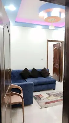 a living room with a blue couch and a chair at Apartment in sherry street near sheraton in Hurghada