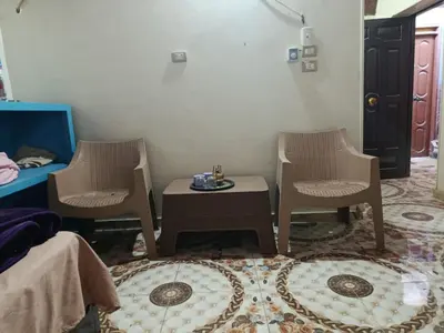 a room with two chairs and a table and a bed at Rooma ka Guest House in Aswan