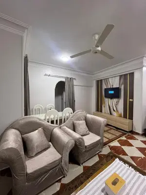 a living room with a couch and a ceiling fan at Dahabiya Apartment in Luxor