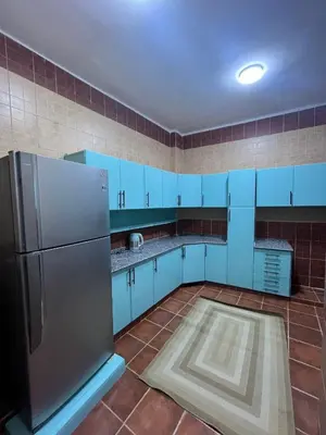a kitchen with blue cabinets and a stainless steel refrigerator at Dahabiya Apartment in Luxor
