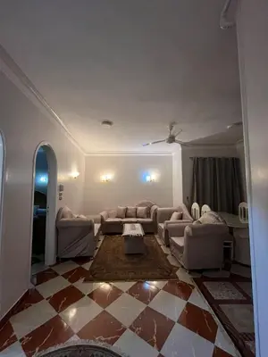 a living room with couches and a checkered floor at Dahabiya Apartment in Luxor