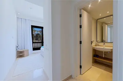 a white bathroom with a sink and a mirror at Stylishly furnished and quietly located apartment in Hurghada