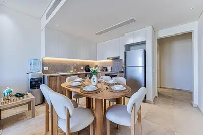 a kitchen with a table and chairs and a refrigerator at Stylishly furnished and quietly located apartment in Hurghada