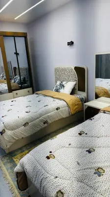 a bedroom with two beds and a mirror at Magwish in Hurghada