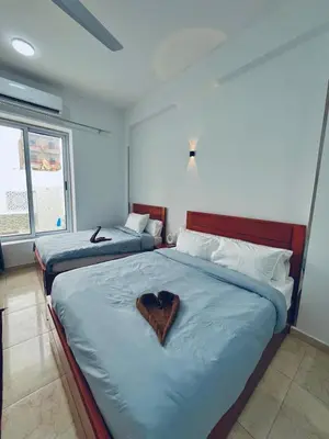 a bedroom with two beds with a heart on them at Farah Hotel in Al Aqālitah