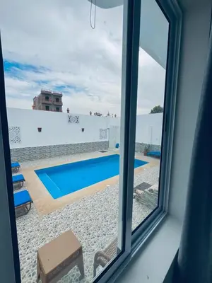 a view of a swimming pool from a window at Farah Hotel in Al Aqālitah
